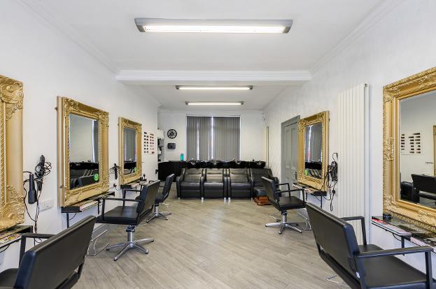 large salon roon with chairs either side and mirrors and sinks at the far end hd hair and beauty